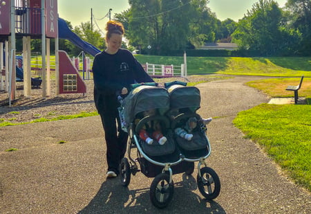 Mother of a donor-conceived baby pushing a stroller outdoors